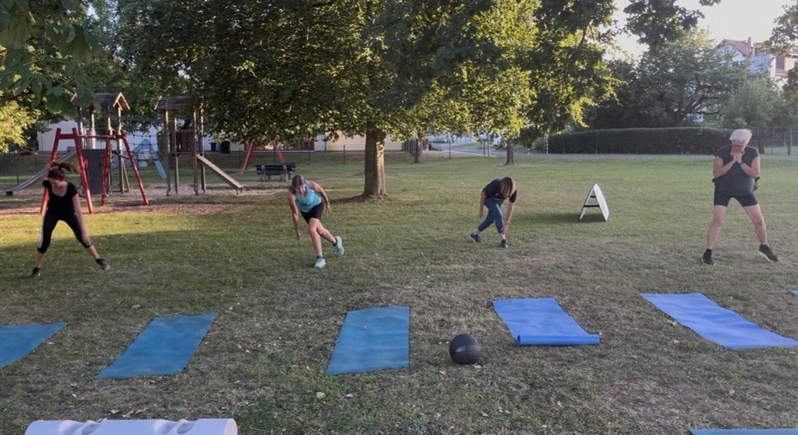 Training auf dem Rasen am Spielplatz, Matten ausgelegt, Ausfallschritte