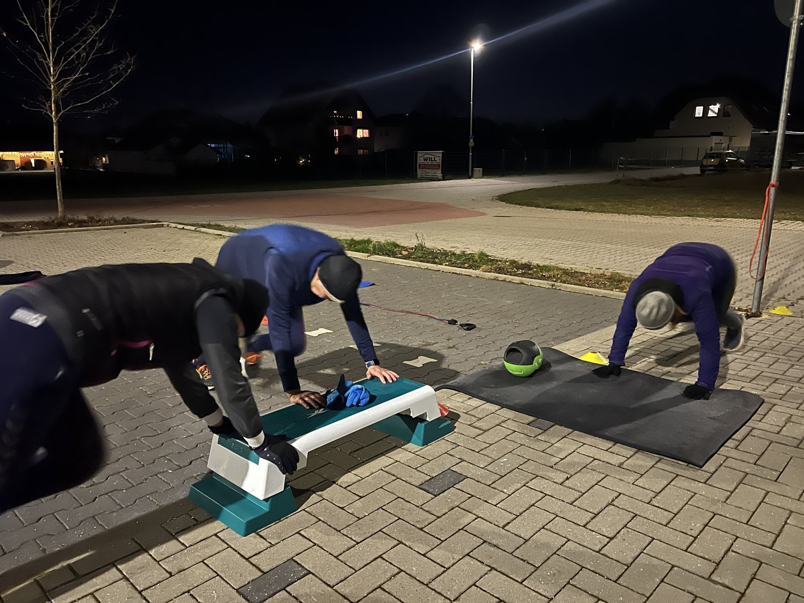 Abendtraining unter Laternen: Übungen an der Bank und auf der Matte