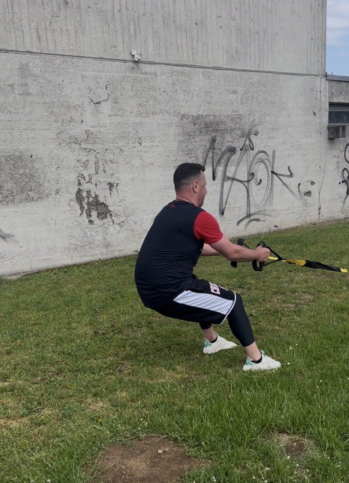 Teilnehmer zieht ein Trainingsband an einer Betonwand