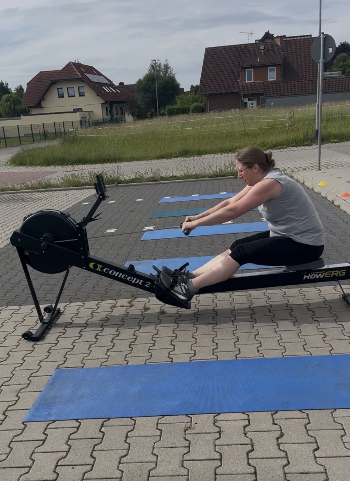 Teilnehmerin auf dem Rudergerät auf dem Parkplatz